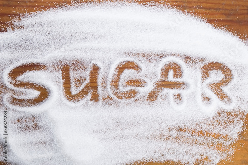 Photo: The word sugar written into a pile of white granulated sugar The word sugar written into a pile of white granulated sugar