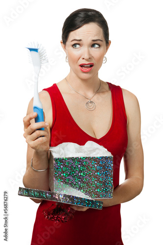 Photo: Disappointed woman holding dish brush gift. Disappointed woman holding dish brush gift.
