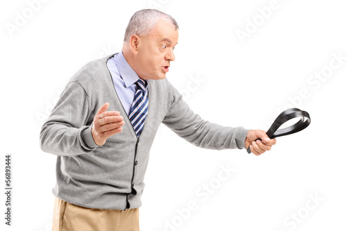 Photo: Angry mature man holding a belt and threatening Angry mature man holding a belt and threatening