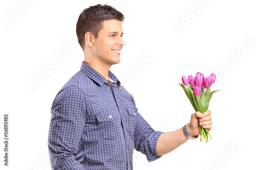 Photo: Smiling guy holding flowers Smiling guy holding flowers