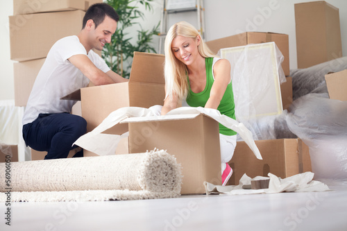 Photo: young couple unpacking or packing boxes young couple unpacking or packing boxes
