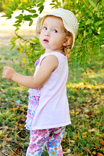Photo: toddler girl in green garden toddler girl in green garden