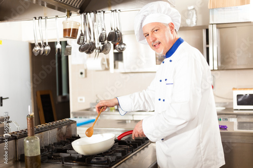 Photo: Portrait of a chef in his kitchen Portrait of a chef in his kitchen