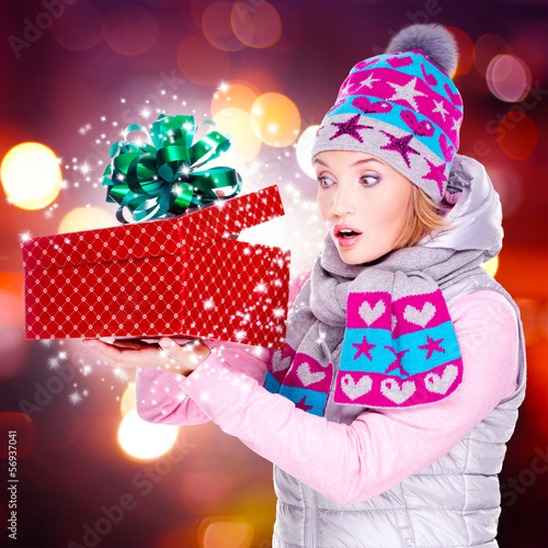 Photo: Woman looks into the christmas box with magic lights Woman looks into the christmas box with magic lights