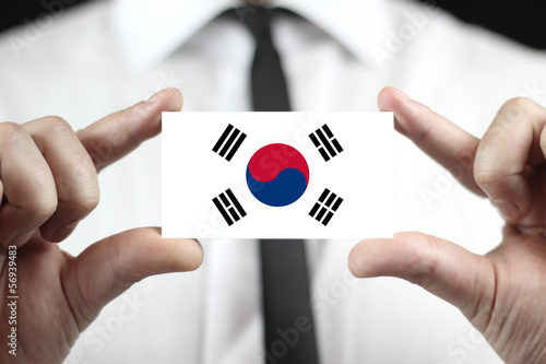 Photo: Businessman holding a business card with South Korea Flag Businessman holding a business card with South Korea Flag