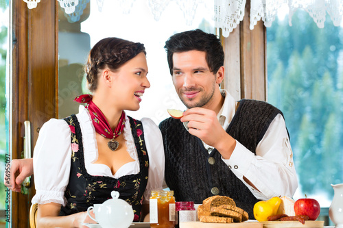 Photo: Young couple in a hunter's cabin eating Young couple in a hunter's cabin eating