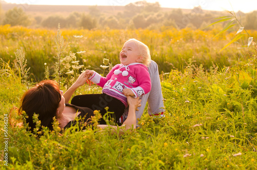Photo: Happy young mother and child having rest near the river Happy young mother and child having rest near the river