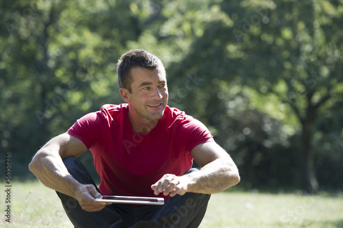 Photo: Man sitting park with a tablet computer Man sitting park with a tablet computer