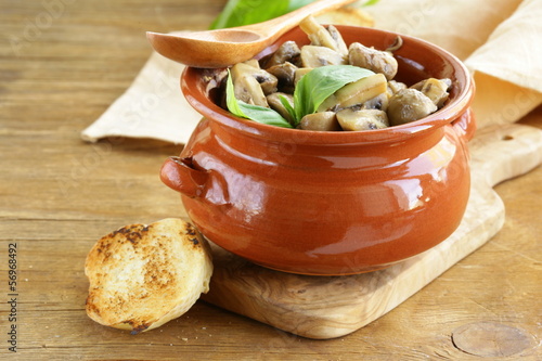 Photo: mushroom ragout of champignons and basil on a wooden table mushroom ragout of champignons and basil on a wooden table