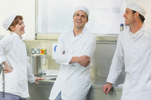 Photo: Three chatting bakers standing in a bakery Three chatting bakers standing in a bakery