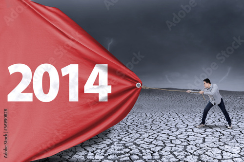 Photo: Asian young man is pulling new year of 2014 Asian young man is pulling new year of 2014