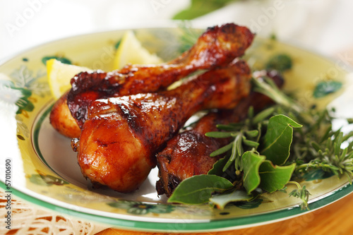 Photo: Roast chicken legs with lemon and herbs on plate. Roast chicken legs with lemon and herbs on plate.
