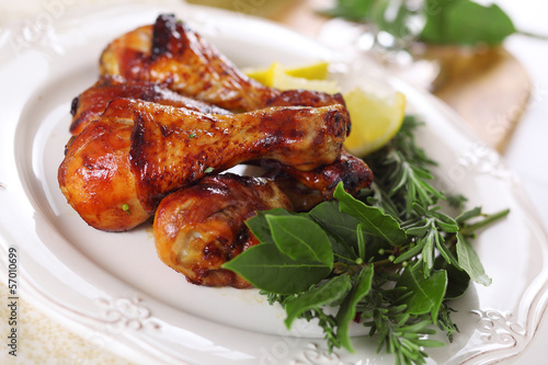Photo: Roast chicken legs with lemon and herbs on plate. Roast chicken legs with lemon and herbs on plate.