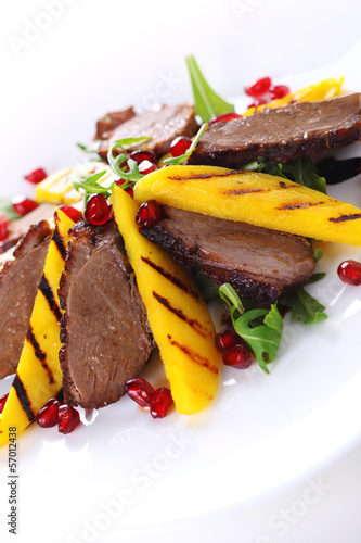 Photo: Salad with duck fillet and grilled mango on white background. Salad with duck fillet and grilled mango on white background.