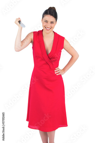 Photo: Smiling elegant brunette in red dress holding knife Smiling elegant brunette in red dress holding knife