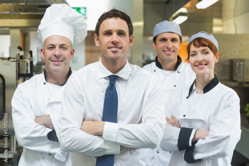 Photo: Restaurant manager standing in front of team of chefs Restaurant manager standing in front of team of chefs