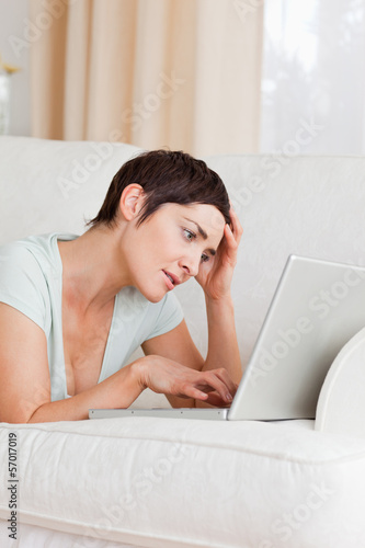 Photo: Tired young woman using a laptop Tired young woman using a laptop