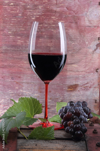 Photo: bicchiere di vino rosso con uva su tino bicchiere di vino rosso con uva su tino