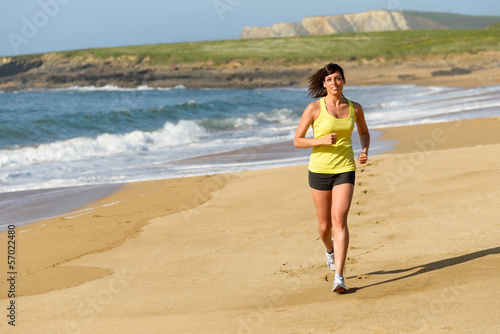 Photo: Woman running on sand beach Woman running on sand beach