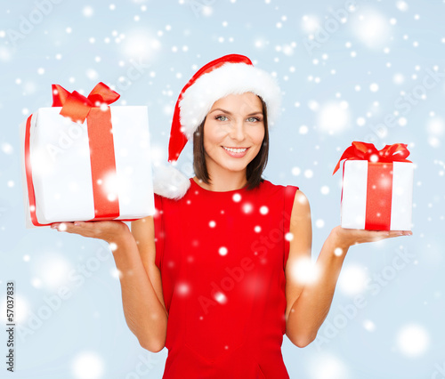 Photo: woman in santa helper hat with many gift boxes woman in santa helper hat with many gift boxes