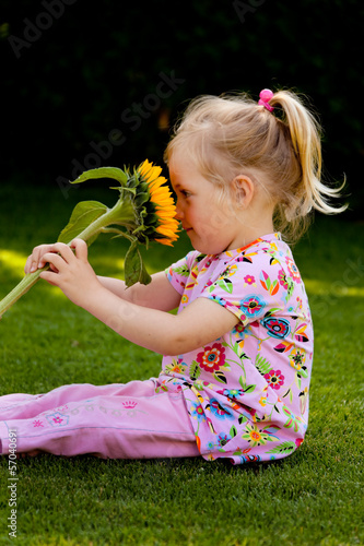 Photo: Kind mit Sonnenblume im Garten im Sommer Kind mit Sonnenblume im Garten im Sommer