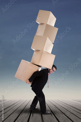 Photo: Businessman lifting boxes vertical Businessman lifting boxes vertical