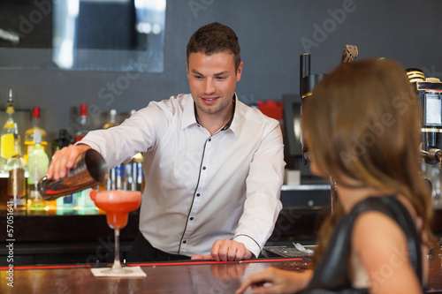 Photo: Handsome bartender serving cocktail to gorgeous woman Handsome bartender serving cocktail to gorgeous woman