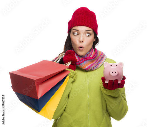 Photo: Concerned Mixed Race Woman Holding Shopping Bags and Piggybank Concerned Mixed Race Woman Holding Shopping Bags and Piggybank
