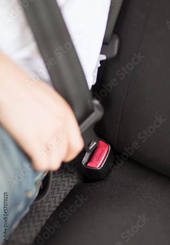 Photo: man fastening seat belt in car man fastening seat belt in car
