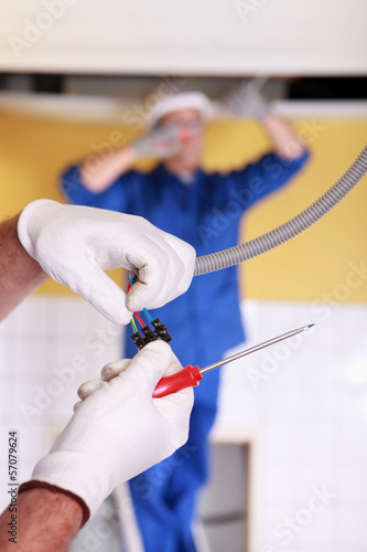 Photo: Two electrician repairing ceiling lighting Two electrician repairing ceiling lighting