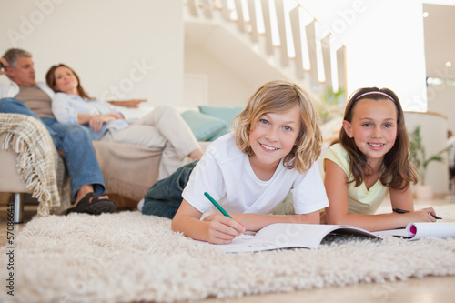 Photo: Brother and sister doing homework on the floor Brother and sister doing homework on the floor