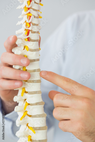 Photo: Close up of male doctor's hand touching skeleton model Close up of male doctor's hand touching skeleton model