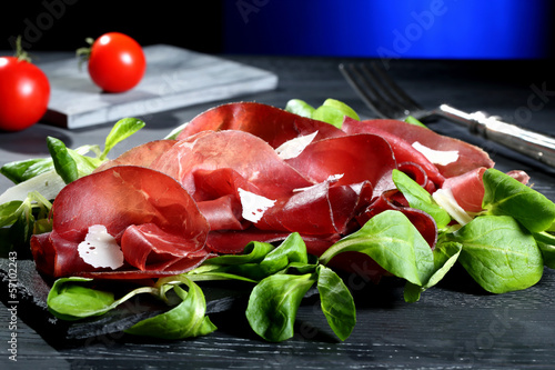 Photo: bresaola su pietra nera sfondo blue bresaola su pietra nera sfondo blue