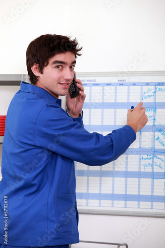Photo: Young worker noting on a slate Young worker noting on a slate
