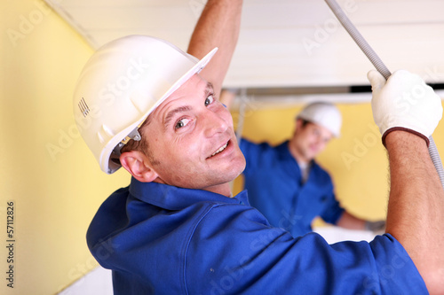Photo: Two plumbers repairing ceiling Two plumbers repairing ceiling