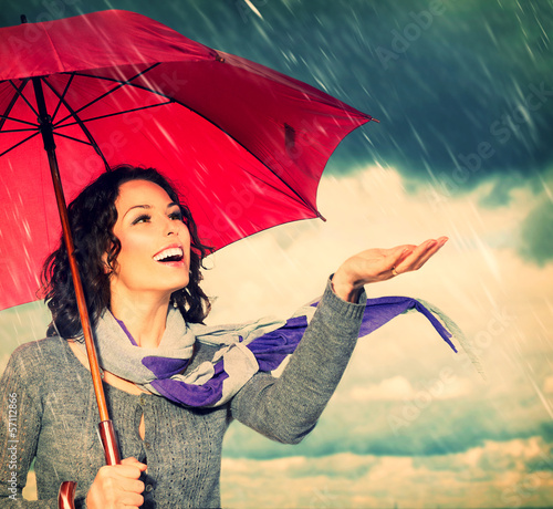 Photo: Smiling Woman with Umbrella over Autumn Rain Background Smiling Woman with Umbrella over Autumn Rain Background