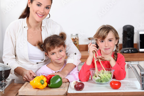 Photo: Mother and daughters making a salad. Mother and daughters making a salad.