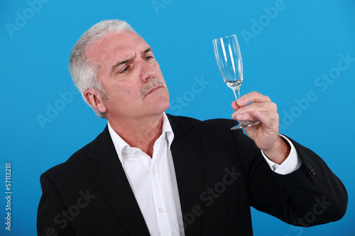 Photo: Man looking at a wine glass Man looking at a wine glass