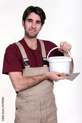 Photo: Man with a pot of grout Man with a pot of grout