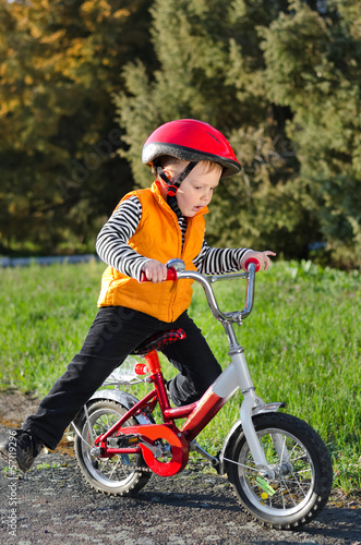 Photo: Cute young boy riding his bike Cute young boy riding his bike