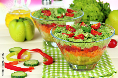 Photo: Tasty salad with fresh vegetables on wooden table Tasty salad with fresh vegetables on wooden table