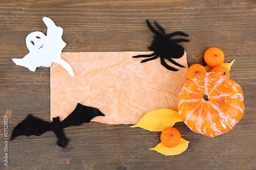 Photo: Old paper with Halloween decorations on grey wooden background Old paper with Halloween decorations on grey wooden background