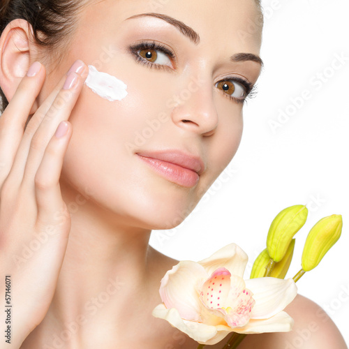 Photo: Beauty face of woman with cosmetic cream on face Beauty face of woman with cosmetic cream on face