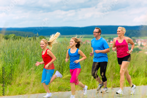 Photo: Happy Family is running outdoors in summer Happy Family is running outdoors in summer