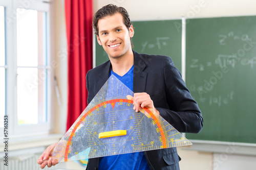 Photo: Teacher with triangle in front of a school class Teacher with triangle in front of a school class