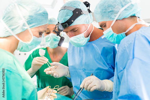 Photo: Surgeons operating patient in operation theater Surgeons operating patient in operation theater