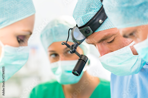 Photo: Surgeons operating patient in operation theater Surgeons operating patient in operation theater
