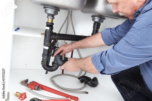 Photo: Hands of Plumber with a wrench. Hands of Plumber with a wrench.