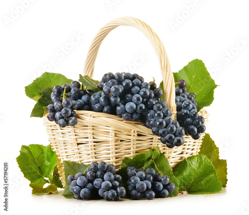 Photo: Wicker basket full of fresh red grapes isolated on white Wicker basket full of fresh red grapes isolated on white
