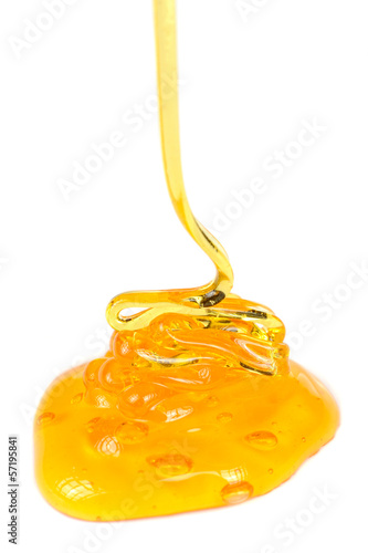 Photo: Stream of Honey Pouring on White Background Stream of Honey Pouring on White Background